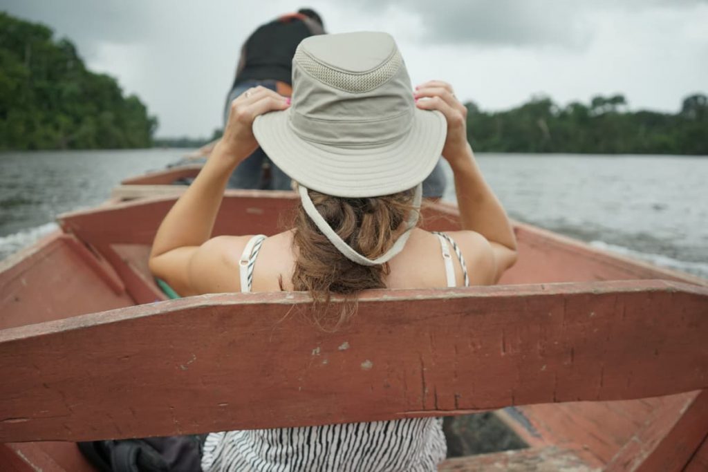 vrouw met hoed op de suriname rivier